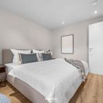 Schlafzimmer mit Bett, Nachttisch und Tür