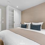 Schlafzimmer mit Bett, Nachttisch und Kleiderschrank.