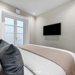 Schlafzimmer mit Bett, TV und Fenster