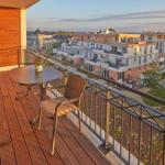 Terrasse mit Tisch und Stühlen, Blick auf Wohngebäude