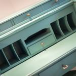 Ein hellblauer Schreibtisch mit Schubladen und Fachern.