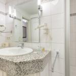 Badezimmer mit Waschbecken, Spiegel und Dusche