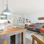 Essbereich mit Holztisch und Wohnzimmer mit Sofa und Couchtisch.
