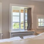 Schlafzimmer mit Blick auf die Landschaft und Meer.