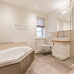 Badezimmer mit Badewanne, Dusche, Waschbecken und Toilette.