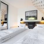 Zwei Betten unter schräger Decke mit Fisch壁纸 und Wandbild.