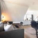 Wohn- und Essbereich mit Sofa, Tisch und Stühlen unter Dachschrägen.