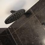 Duschkopf und Handbrause in schwarzem Design auf dunklem Boden