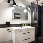 Badezimmer mit Dusche, Waschtisch und Spiegel