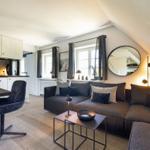 Wohnbereich mit Sofa, Tisch und Küchenzeile unter schrägem Dach