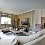 Wohnzimmer mit Sofa, Fernseher und Kamin