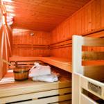 Sauna mit Holzbank, Bademantel und Eimer.