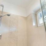 Dusche mit Glaswand, Duschbrause und Fenster