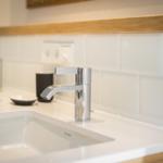 Waschbecken mit Chromarmatur und Holzoberkante