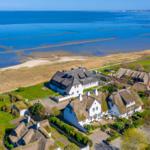 Haus mit strohgedecktem Dach, Garten und Blick auf die Nordsee.