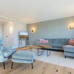 Wohnzimmer mit Sofa, Sessel und Fernseher
