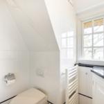 Badezimmer mit Dusche, Toilette und Waschbecken unter einem Dach