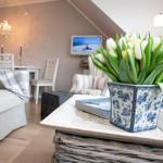 Wohnzimmer mit Sofa, Esstisch und Blumen in Blumentopf.