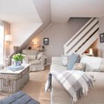 Wohnzimmer mit Sofa, Sessel und Kamin im Dachgeschoss