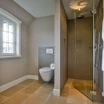 Badezimmer mit Dusche, Toilette und Fenster