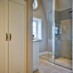 Badezimmer mit Duschkabine, Waschbecken und Fenster