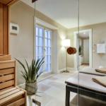 Sauna mit Holzbank, Pflanze und Liege mit Decke
