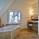 Badezimmer mit Badewanne, Waschbecken und Fenster