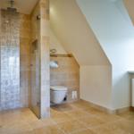 Dusche mit Glaswand, Toilette und Badewanne in Dachschrägen