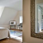 Schlafzimmer mit Dachschrägen, Spiegel und Bett