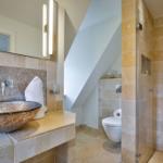 Badezimmer mit Dusche, Toilette und Waschtisch mit Keramikwaschschale.
