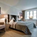 Schlafzimmer mit Bett, Sessel und Fenster