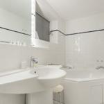 Badezimmer mit Waschbecken, Badewanne und Heizkörper