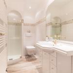Bathroom with shower, toilet, and sink with mirror.
