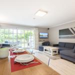 Essbereich mit Tisch und Stühlen, Wohnzimmer mit Sofa und Fernseher.