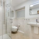 Badezimmer mit Dusche, Toilette und Waschbecken.