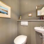 Badezimmer mit Toilette, Waschbecken und Spiegel. Wandbild und Dekoration.