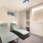 Zwei Liegestühle in einem Raum mit Schränken und Fenster