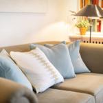 Ein Sofa mit Kissen und einer Lampe im Hintergrund.