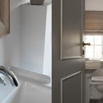 Bathroom with sink, toilet, and window with flowers.