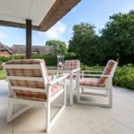 Terrasse mit weißen Stühlen und Tisch unter Dach