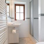 Badezimmer mit Dusche, Waschbecken und Fenster
