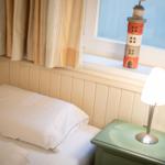 Schlafzimmer mit Bett, Nachttisch und Fenster mit Laterne.