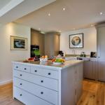Kitchen with island, wooden floor, and light walls.