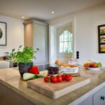 Kitchen with countertop, fruit, vegetables, and kitchen cabinets.