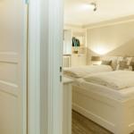 Bedroom with double bed, nightstand, and bookcase.