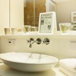 Sink with mirror, towels, and bath rules.