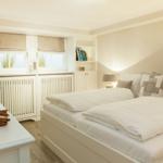 Bedroom with double bed, windows, and shelves.