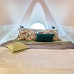 Schlafzimmer mit Bett unter Dachschrägen und runden Fenster
