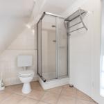 Badezimmer mit Dusche, Toilette und Waschbecken.