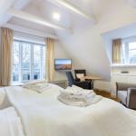 Schlafzimmer mit Dachschräge, Bett, TV und Sitzgelegenheiten